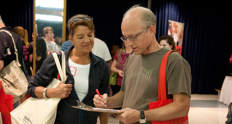 Two parents fill out a form during Preview